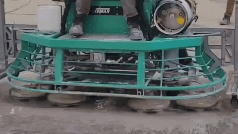 Looped GIF of a teal ride-on polisher moving side to side with the polishing heads spinning.
