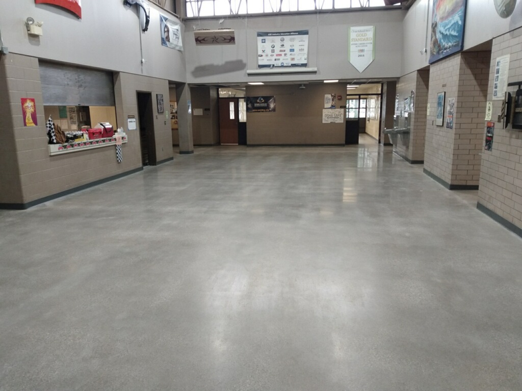 Picture of Fort Wayne Community School's Anthis Career Center's main hallway and vestibule with our StrongTread Remodel system reflecting the light from the windows at the top of the photo.