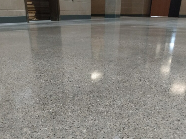 Close up picture of Fort Wayne Community School's Anthis Career Center's main hallway and vestibule with our StrongTread Remodel system reflecting the light from the room's windows.